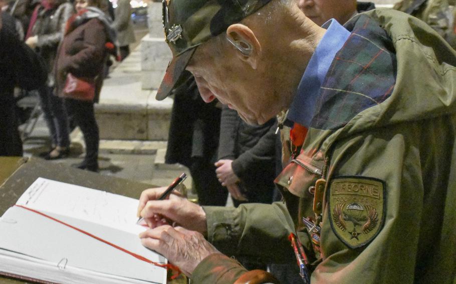 Stephen Weiss, an American World War II veteran living in London, signs a commemorative book following a ceremony to rekindle the Eternal Flame at the Tomb of the Unknown Soldier under the Arc de Triomphe in Paris on Friday, Feb. 14, 2020. The ceremony honored the Office of Strategic Services, which Weiss, 94, had worked with behind enemy lines after being separated from his infantry unit during WWII.