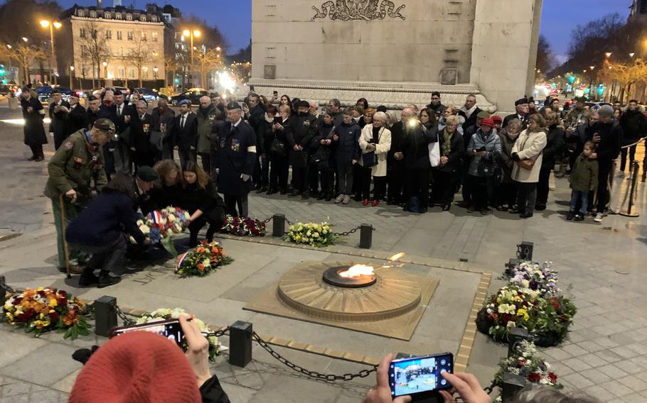 Stephen Weiss, 94, standing on the left, helped lay a wreath at the Eternal Flame at the tomb of France's unknown soldier under the Arc de Triomphe on Friday, Feb. 14, 2020, along with, left to right, French-American high school student Margot Sarkozy, Special Forces Lt. Col. Travis Moliere, Beatrice Boussens, the grandaughter of an Italian-Jewish member of the Office of Strategic Services, and French-American high school student Josephine Ligout. Weiss is one of the few American World War II veterans alive who worked with the OSS behind enemy lines in France during the war. Sarkozy and Ligout had won national prizes from a French veterans organization.