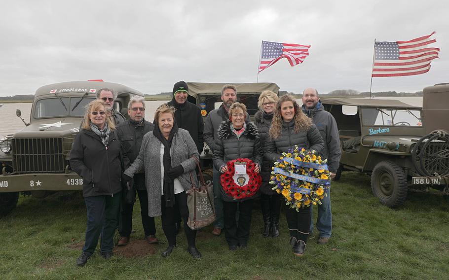 Family members of the crew of a B-17 bomber that crashed in a river in England during World War II pose for a group photo prior to a remembrance ceremony for their crew held in Ramsholt, England Feb. 20, 2020.