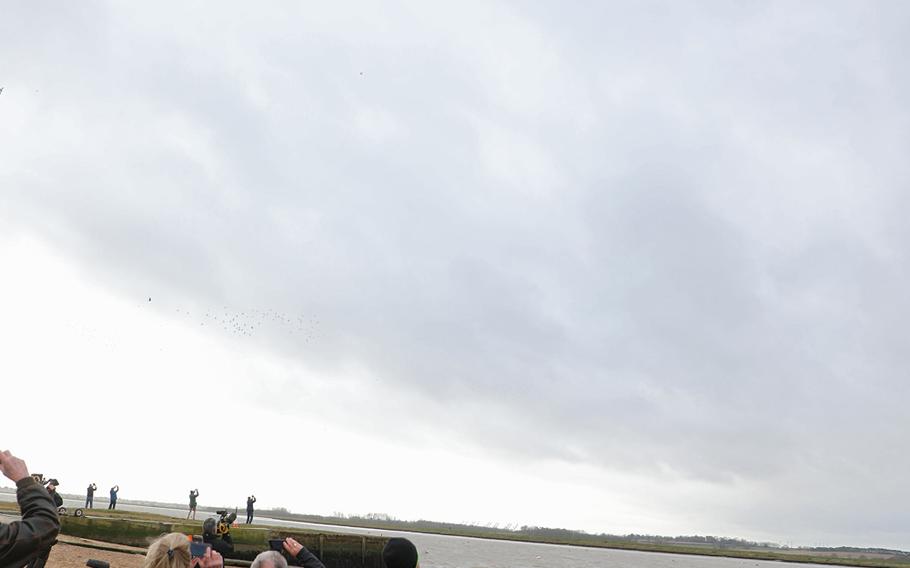 A U.S. Air Force C-130 and CV-22 from RAF Mildenhall are watched as they fly over the Deben River in England on Thursday, Feb. 20, 2020, 75 years to the day that an American B-17 Flying Fortress crashed there, killing eight of the 10 crew on board.