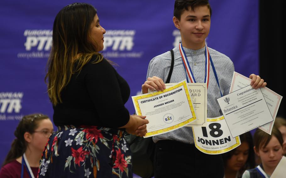 Spelling bee champion Jonnen Messer, a seventh grader at Ramstein Middle School, Germany, holds up his prize certificates at the the conclusion of the European PTA Regional Spelling Bee on Saturday, Feb. 29, 2020, at Ramstein Air Base.