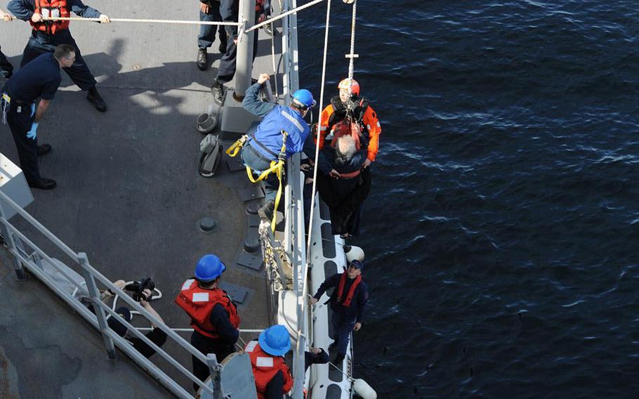 Sailors hoist rescued crew members of a Turkish boat that was burning on to the destroyer USS Ross in the Sea of Marmara, offshore of Turkey.