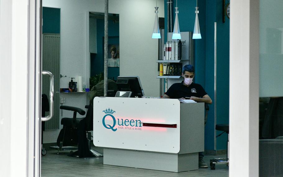 An employee of a hairdressing salon in Kaiserslautern wears a face mask as he waits for customers to come in on Tuesday, March 17, 2020. Hairdressing salons are one of numerous businesses exempted from restrictions imposed at the local and federal levels, seeking to stem the spread of the coronavirus in Germany.