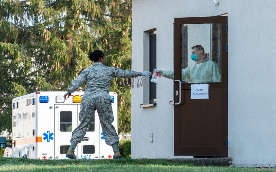 A lab sample is passed to a medical technician from the COVID-19 clinic at Ramstein Air Base, Germany, March 20, 2020.