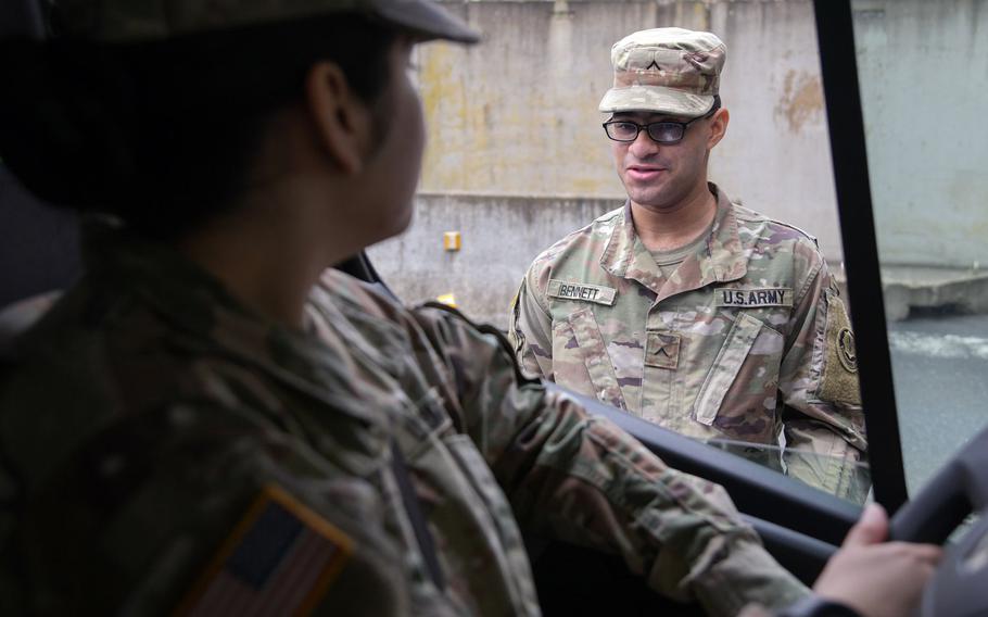U.S. Army Pvt. Rapheal Bennett, 2nd Squadron, 2nd Cavalry Regiment, asks health questions to a service member entering Rose Barracks, Vilseck, Germany on March 18, 2020, as part of the military's coronavirus response.