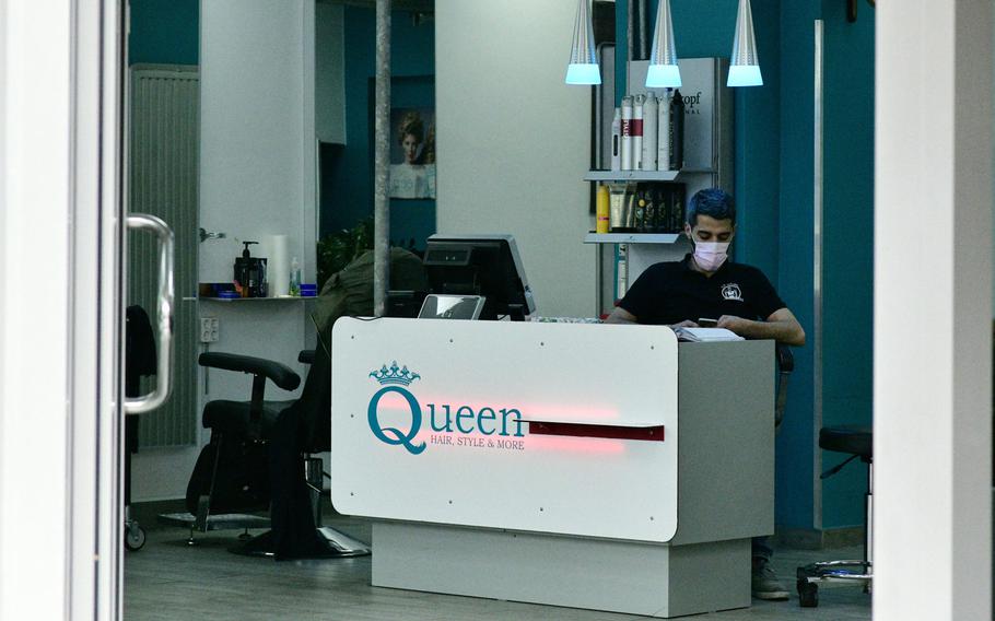 An employee of a hairdressing salon in Kaiserslautern wears a face mask as he waits for customers Tuesday, March 17, 2020. Salons were ordered closed soon afterward in response to the coronavirus, but should be prepared to reopen May 4, German Chancellor Angela Merkel said Wednesday.