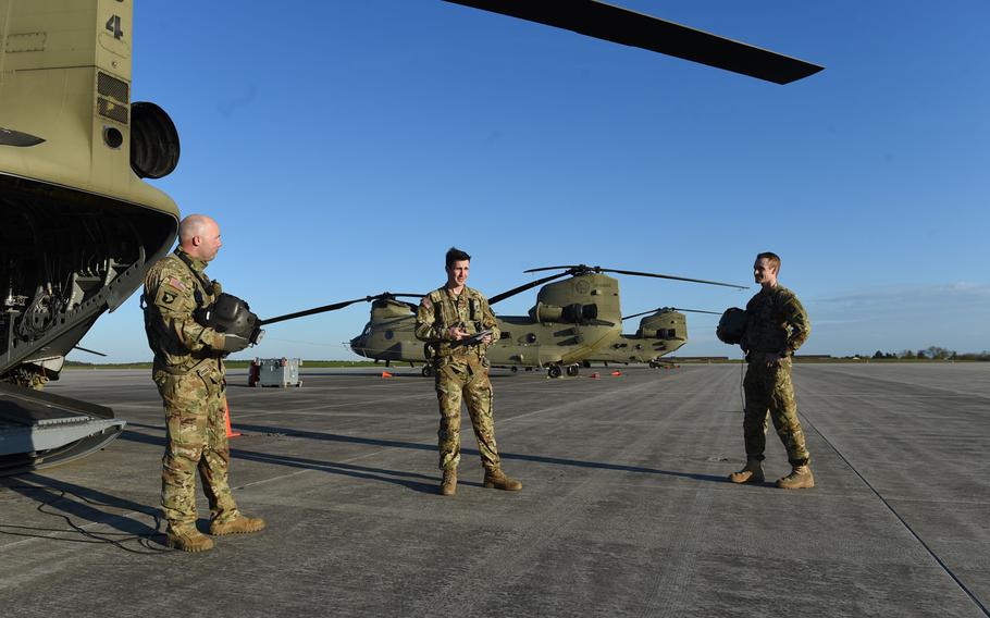 From left, Staff Sgt. Elijah Joice, a flight engineer instructor, 1st Lt. Timothy Mills, a pilot, and Chief Warrant Officer 2 Dylan Hawkins, a pilot, all with the 12th Combat Aviation Brigade, conduct a safety brief before a pilot progression training exercise on Ansbach, Germany, April 20, 2020.