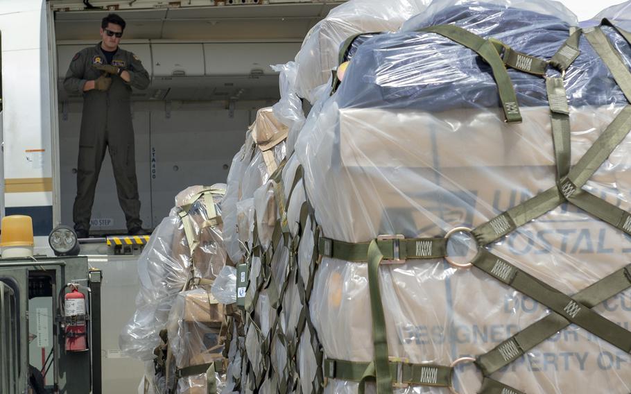 Navy Petty Officer 2nd Class Jacob Edmondson, assigned to Fleet Logistics Support Squadron 58, helps guide mail bound for Europe aboard a C-40A plane at Camp Lemonnier, Djibouti, April 22, 2020.