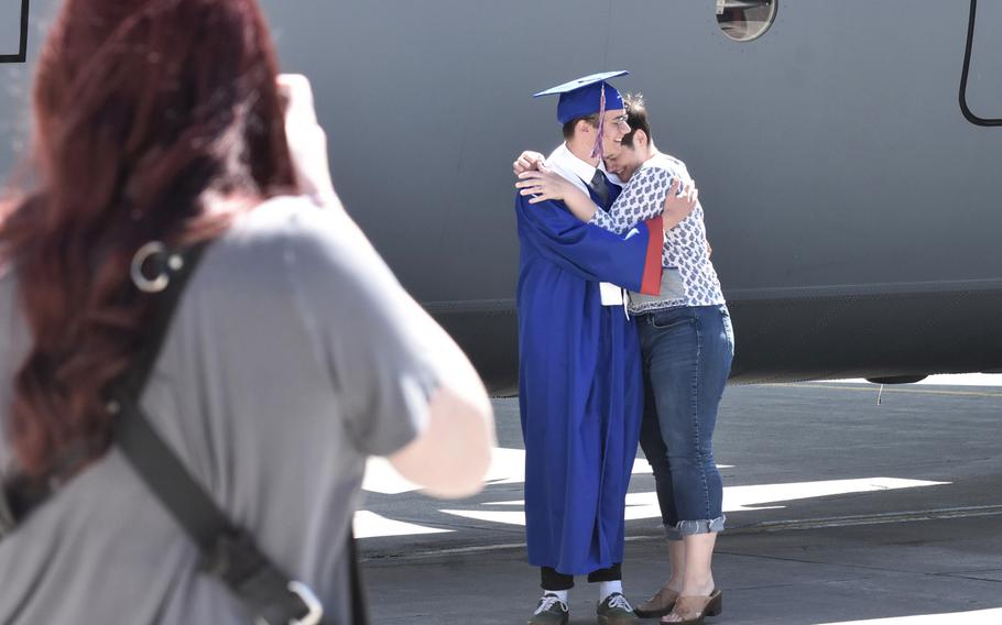 Ramstein High School senior Michael Brink, 18, hugs his mom, Shauna, while getting his photo taken by a C-130J Super Hercules parked on the ramp at Ramstein Air Base, Germany, May 18, 2020. The 86th Airlift Wing at Ramstein made the aircraft available for senior photos at the request of the Defense Department school system.