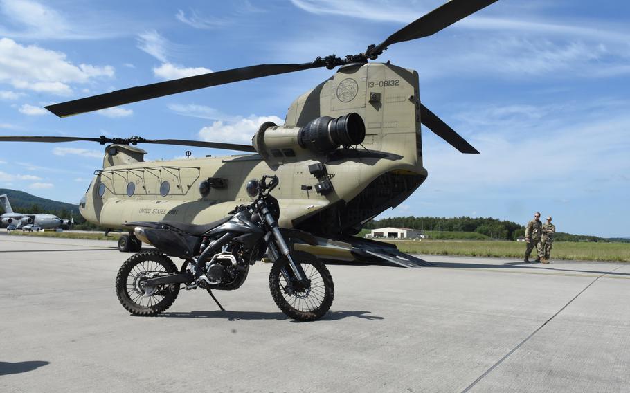 A small motorcycle is seen next to an Army CH-47 Chinook helicopter parked on a ramp at Ramstein Air Base, Germany, on Wednesday, May 27, 2020, during the Agile Wolf exercise. The motorcycle is one piece of equipment the 435th Contingency Response Squadron at Ramstein may take with it when opening a base somewhere.