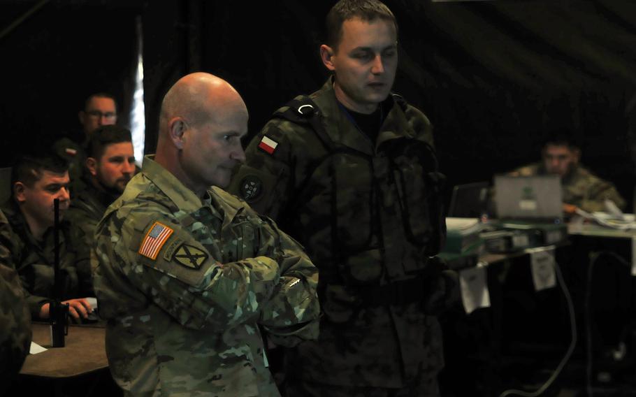 Lt. Gen. Christopher Cavoli, United States Army Europe  commander, receives an intelligence report on Polish forces and assets participating in Exercise Puma, in Orzysz, Poland, Feb. 22, 2018.