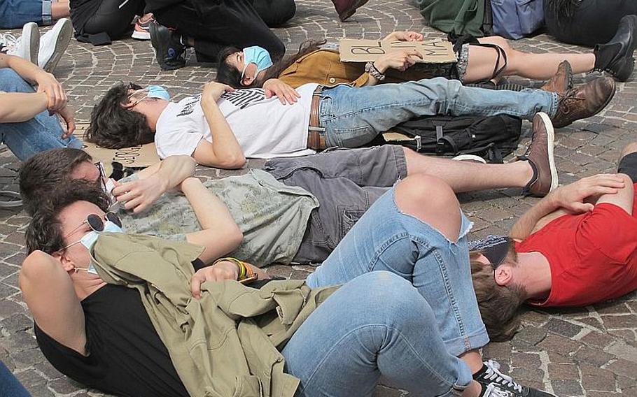 Demonstrators against U.S. racism and police brutality gathered in Vicenza, Italy on Saturday, June 6, 2020, lay on the ground after hearing a tape of the police killing of George Floyd, in which Floyd repeatedly said he couldn't breathe. Floyd died after a white police officer kept his knee pressed to Floyd's neck for nearly nine minutes.