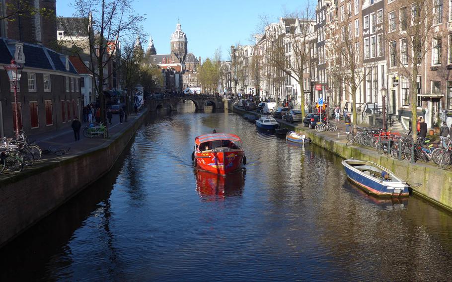 A boat plies an Amsterdam canal in April 2015.  Personnel assigned to U.S. Army Garrison Rheinland Pfalz may travel internationally but only to about 25 countries in Europe, a new general order from 21st TSC says.