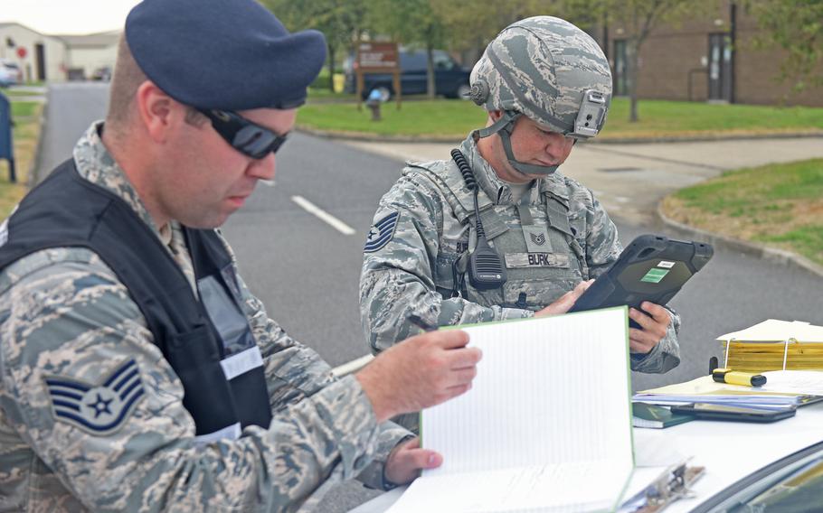Air Force Staff Sgt. Jeremiah Johnson, left, of the 100th Security Forces Squadron, references his checklist as the on-scene commander during a mission assurance exercise at RAF Mildenhall, England, in August 2018. Johnson died at his off-base home June 27, 2020.