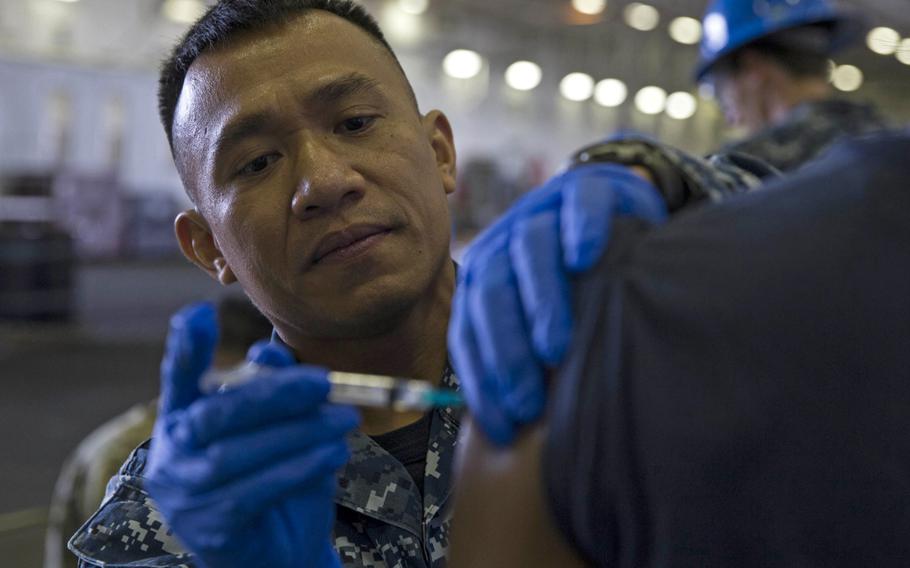 Hospital Corpsman 1st Class Ronald Valdez administers a flu shot to a sailor aboard the USS Gerald R. Ford, Oct. 16, 2018. While some military commands in Europe have begun mass vaccination campaigns for flu, U.S. Navy health officials in Naples, Italy, say they may not have the vaccine until December.