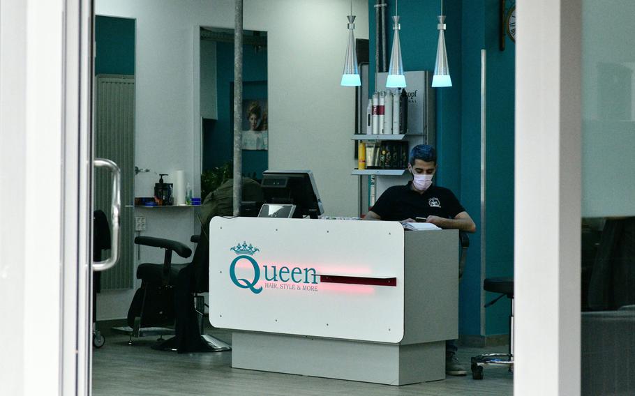 An employee of a hairdressing salon in Kaiserslautern, Germany, wears a face mask as he waits for customers  in March 2020. Hairdressing salons will be allowed to remain open when new restrictions aimed at stemming the spread of the coronavirus in Kaiserslautern take effect on October 28, 2020, city officials said.