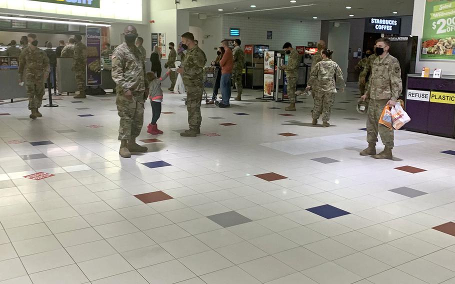 Members of U.S. Army Garrison Bavaria stand away from each other as they wait to order lunch at the food court on Tower Barracks, Grafenwoehr, Germany on Nov. 2, 2020, when new coronavirus restrictions took effect.