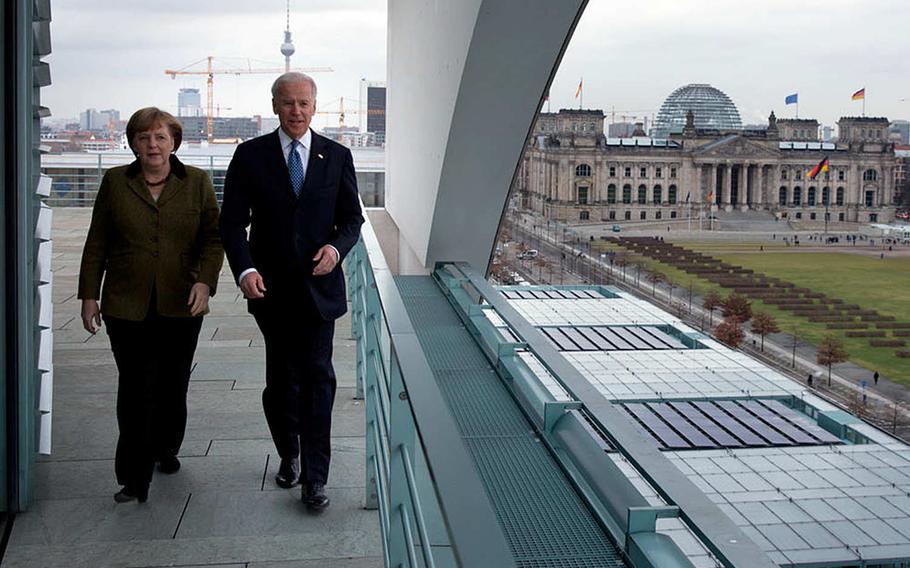 Then-Vice President Joe Biden and German Chancellor Angela Merkel walk on the balcony outside the chancellor's office overlooking Berlin, Germany, in February 2013.  President-elect Joe Biden is expected, in one of his first military policy moves, to reverse the Trump administration's plan to withdraw troops from Germany.