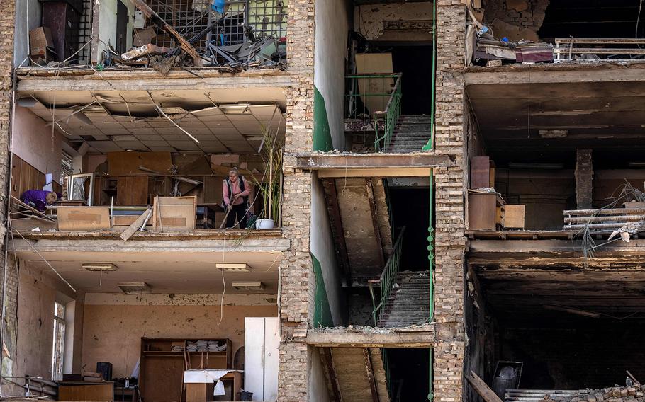 Women clean in a building with a collapsed facade at the Vizar company military-industrial complex, after the site was hit by overnight Russian strikes, in the town of Vyshneve, southwestern suburbs of Kyiv, on April 15, 2022. 