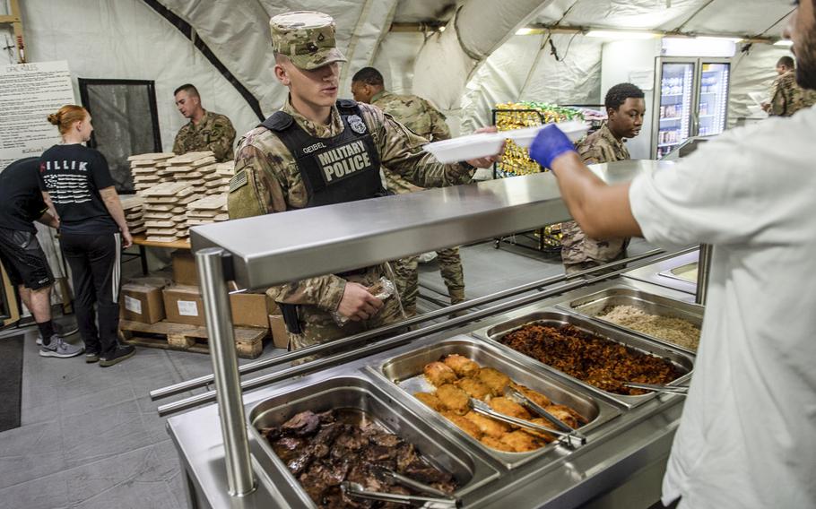 Soldiers deployed to the Polish military base in Powidz are served food at the dining facility, Aug. 27, 2019.

