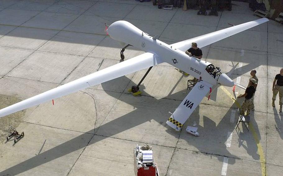 Members of the 11th Reconnaissance Squadron from Indian Springs, Nev., perform preflight checks on a Predator drone before a mission in November 2001.
