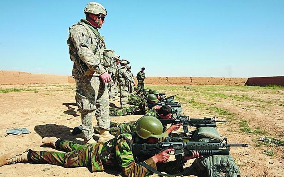 Soldiers from Company D, 2nd Battalion, 2nd Infantry Regiment, watch as Afghan troops try to zero their weapons during marksmanship training in Maiwand district, Kandahar province, Afghanistan, in this 2009 photo.