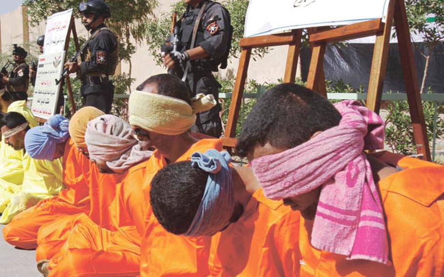 Blindfolded suspects are guarded Thursday by Iraqi special operations commandos, in Basra, Iraq. Security forces arrested 18 men and seized large quantities of explosives, ammunition, rifles and weapons equipped with silencers, along with Katyousha and Grad rockets. What happens next depends on how well the arresting officers coordinated with judicial investigators, U.S. forces say.  If proper procedures have not been followed, their cases will likely be thrown out by a judge.  