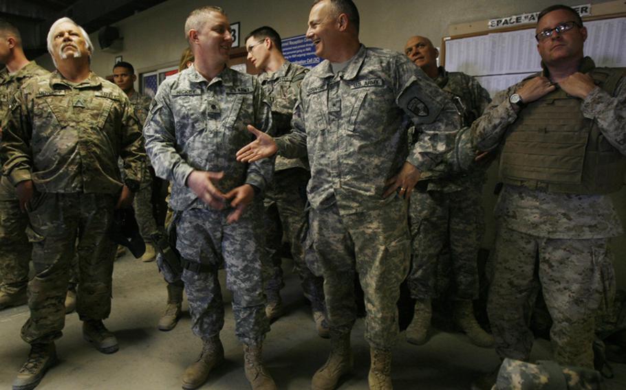 Brig. Gen. Tom Cosentino, who was in the Pentagon when it was attacked on 9/11, shakes hands with Lt. Col. Chris Hickey, center left, at the Pax Terminal at Bagram Air Base in Afghanistan after hearing that Osama bin Laden was killed in Pakistan on May 1, 2011.

