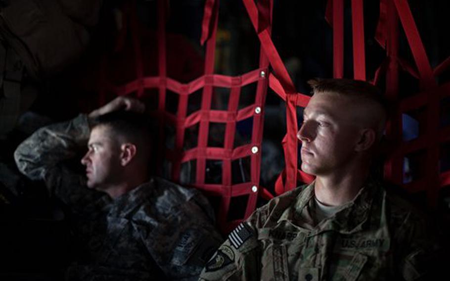 Spc. Benjamin Knapp, 24, right, of Madison, S.D., and Maj. Douglas Moore, 40, left, of Columbus Ohio, both with the 4th Brigade Combat Team, 101st Airborne Division out of Fort Campbell, Ky., look out the window aboard a C-130 cargo plane as they begin the trip home after leaving Forward Operating Base Sharana in Paktika province upon completion of a deployment Sunday, Aug. 7, 2011 in Afghanistan. 