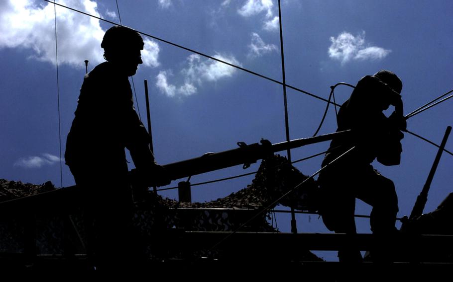 Soldiers raise an antenna mounted to the top of a Stryker combat vehicle. The mobility of the Stryker lets signal teams move around the battlefield and retransmit communications to distances that would otherwise be unavailable.
