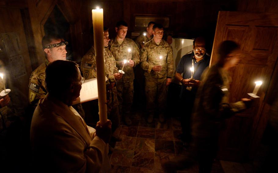 U.S. Army chaplain, Lt. Col. Michael Travaglione, attached to the 1st Cavalry Division, leads members of his congregation into the chapel at Forward Operating Base Salerno, in Khost province Afghanistan, during an Easter vigil held Saturday night.