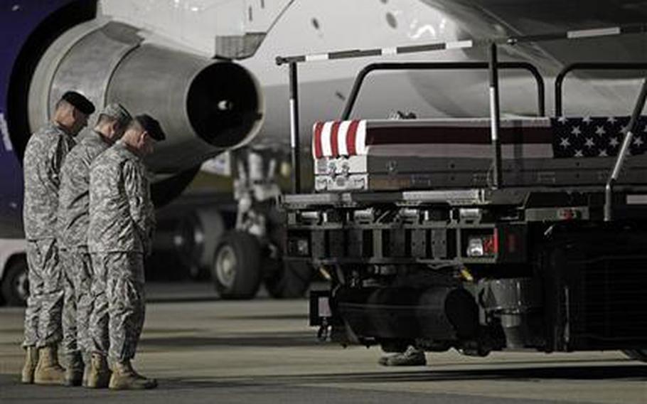 Chaplain Col. Dennis Goodwin, left, directs a prayer over the transfer case containing the remains of Army Capt. Bruce K. Clark of Spencerport, N.Y., upon arrival at Dover Air Force Base, Del. on Thursday May 3, 2012. The Department of Defense announced the death of Clark who was supporting Operation Enduring Freedom in Afghanistan.  