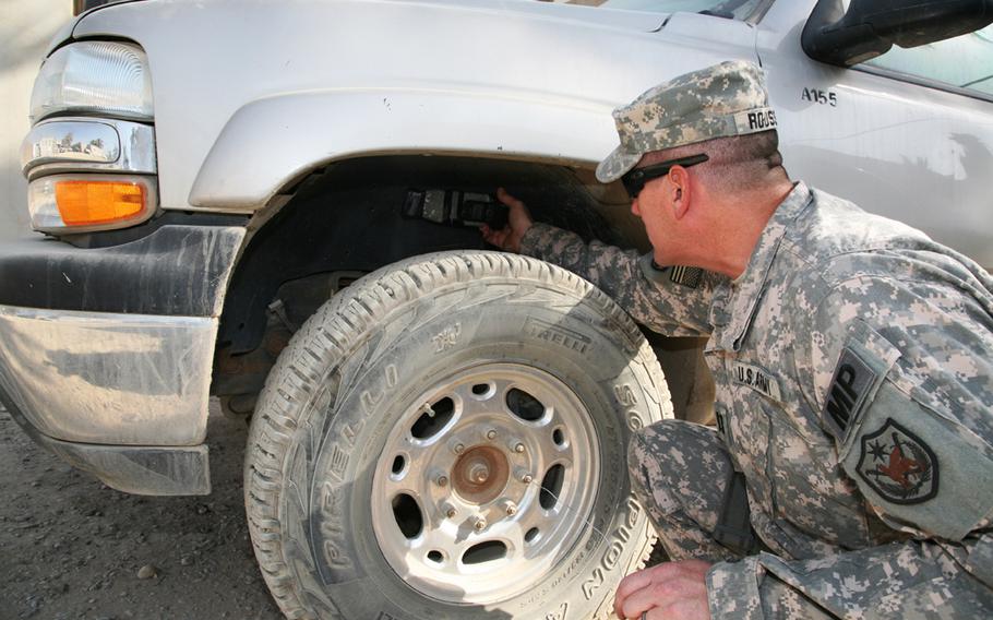 U.S. Army Capt. Daniel T. Rosseau, a member of the Iraqi Police Transition Team, demonstrates a typical placement for a magnetically adhesive improvised explosive device - a "sticky bomb."