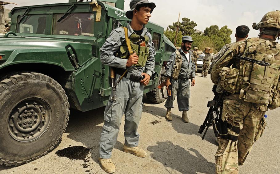Afghan National Police stand guard on a joint patrol with coalition forces in the Alingar District Center, Laghman province, in this July 2011 photo.