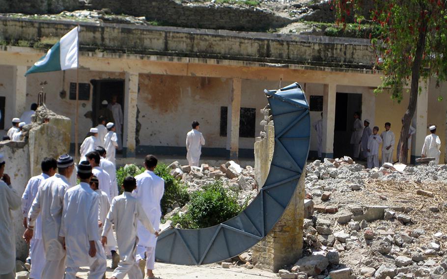 Pakistani boys go to class in a school destroyed by a Taliban bombing in 2009.