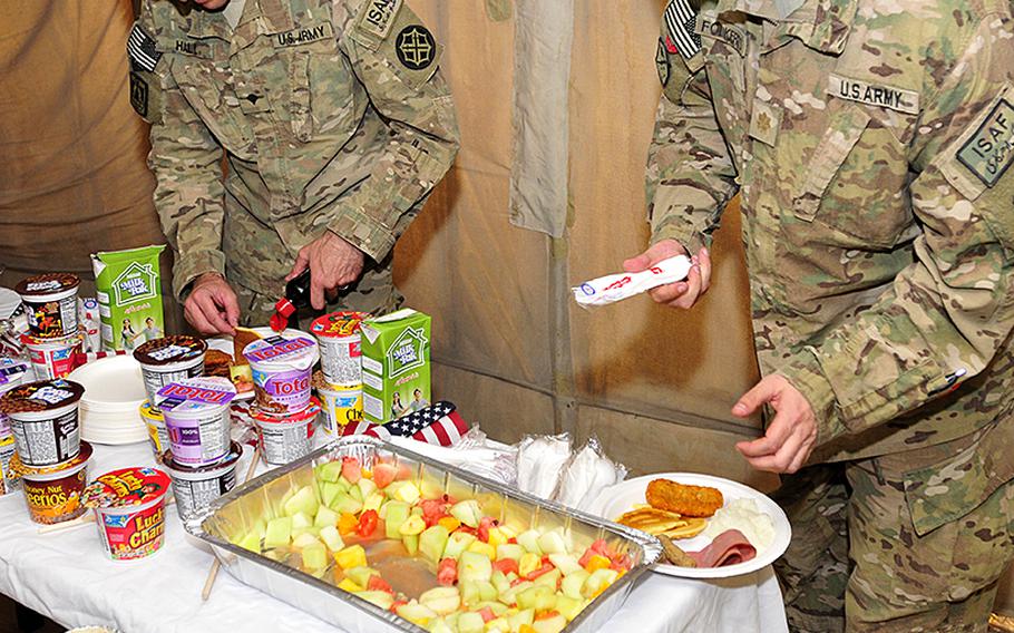 Soldiers grab a plate of food during a Fourth of July service with breakfast at Kandahar Airfield, Afghanistan, on July 8, 2012.