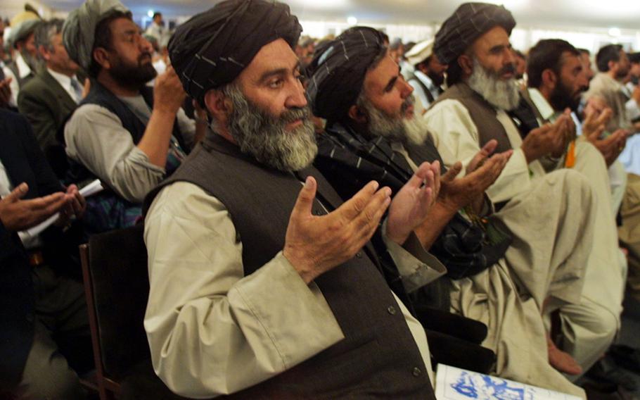 In a June 11, 2002 photo, delegates pray during the opening session of the Loya Jirga in Kabul, Afghanistan