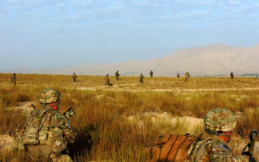 Two soldiers from 2nd Platoon, Battle Company, 2nd Battalion, 503rd Infantry Regiment, Task Force 173rd Airborne Brigade Combat Team, pull security while the soldiers of Weapons Company, 3rd Kandak, 201st Corps, Afghan National Army move toward the village of Salar in Afghanistan's Wardak province, during Operation Assaly II July 24, 2012. 