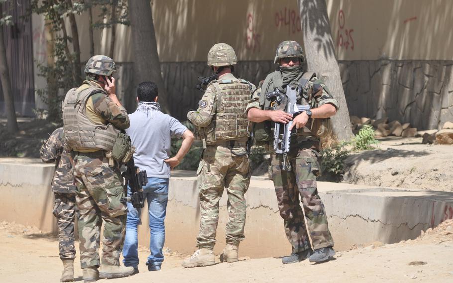 Coalition troops at the scene of an attack in Kabul on June 25, 2013, in which armed suicide bombers struck in a heavily fortified area of Kabul near the presidential palace. The attackers, who were wearing coalition military uniforms, made it through several checkpoints using fake documents. 