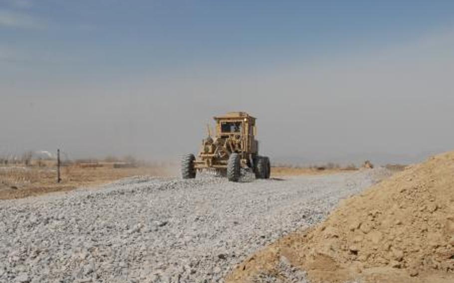 In Afghanistan, a road grader spreads gravel in Regional Command-South in February 2012. Poor contract oversight has not only wasted money; in one case, it may have led to the deaths of U.S. troops.