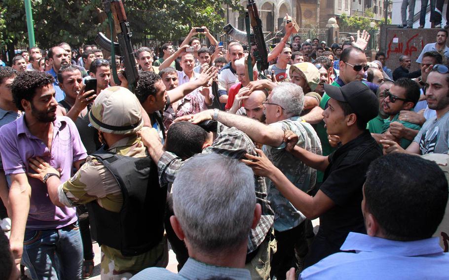 Egyptians security forces escort Islamist supporters of the Muslim Brotherhood out of the al-Fatah mosque in Cairo, Egypt, Saturday, August 17, 2013, after hundreds of Islamist protesters barricaded themselves inside the mosque overnight, following a day of fierce street battles that left scores of people dead. 