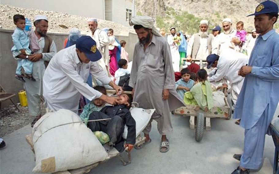 Workers vaccinate young children during National Immunization Days in Afghanistan.