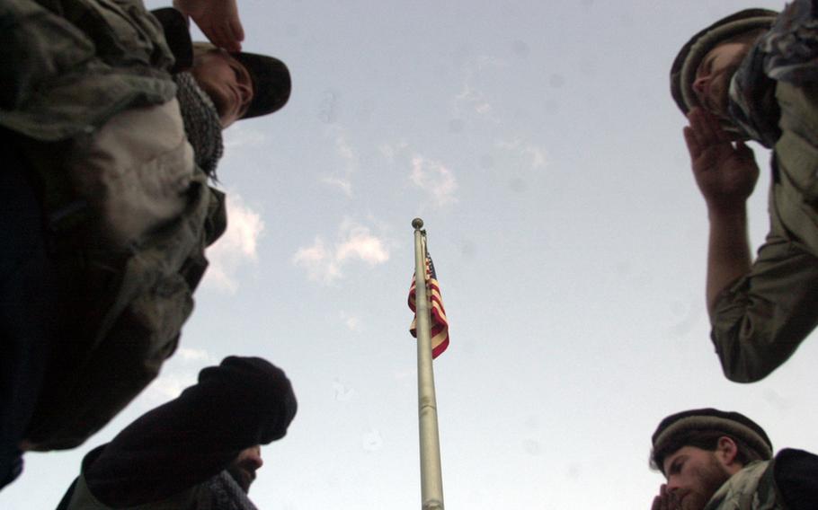 A contingent of 5th Special Forces Group soldiers pay their final respects to fallen friends and comrades in a private solemn ceremony at the U.S. Embassy before turning the compound over to Marine guards in Dec. 2001.