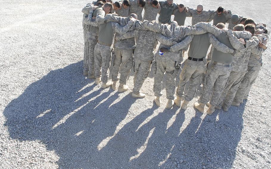 Soldiers with 4th Engineer Battalion, 62nd Engineer Sapper Company, 3rd Platoon pray before a mission conducted the day after their convoy was hit by three roadside bombs. 