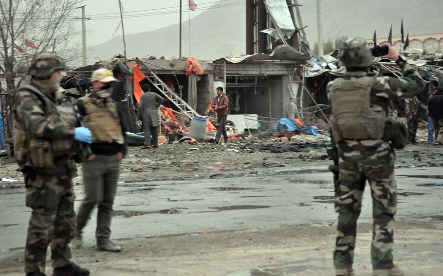 Investigators with the NATO-led coalition scan the scene of a bombing Saturday, Nov. 16, 2013, in Kabul near the site of a government-sponsored conference of elders convening Thursday to discuss a security pact that will determine whether U.S. troops stay in Afghanistan past 2014.

Alex Pena/Stars and Stripes