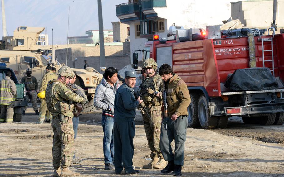 Troops with the International Security Assistance Force  confer with Afghan officials at the scene of a suicide bombing in Kabul on Monday, Feb. 10, 2014. The bombing  killed at least two foreign contractors working for ISAF.