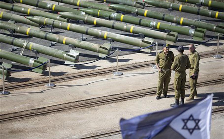 Israeli naval officers stand at a military port in the Red Sea city of Eilat, Israel, on Monday, March 10, 2014, with dozens of rockets seized from a Panama-flagged civilian cargo ship that Israel intercepted off the coast of Sudan.