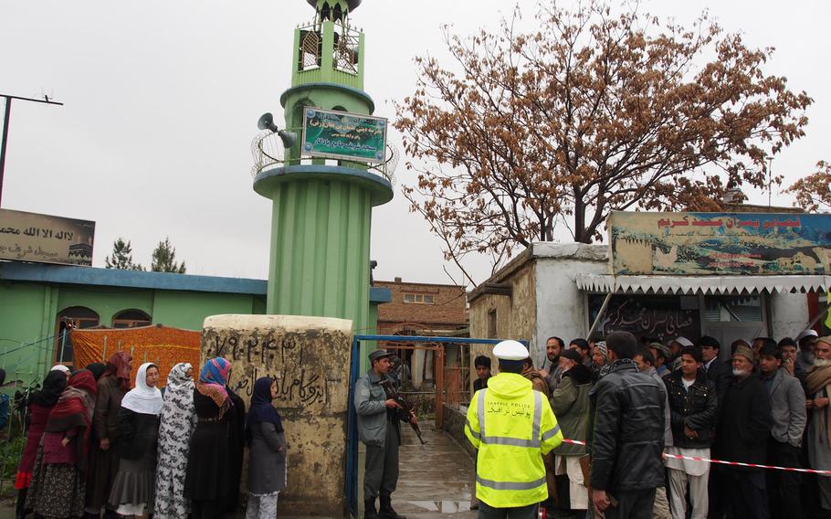 Men and women wait in separate lines for a polling station in central Kabul to open on Saturday, April 5, 2014. Despite threats of violence from the Taliban, millions of Afghans went to the polls to elect a new president. 