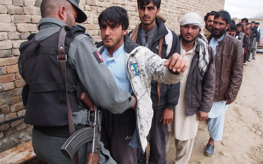 Voters are searched at a polling station on the outskirts of Kabul on Saturday, April 5, 2014. Security was tight across Afghanistan, and all roads into the capital were closed for the election. 