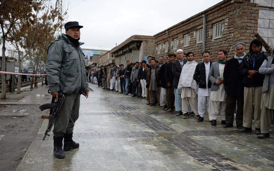 Afghan men line up outside a mosque being used as a polling station in Kabul on election day, Saturday, April 5, 2014. Long lines could be found at many polling stations as Afghans braved the rain and Taliban threats to vote.